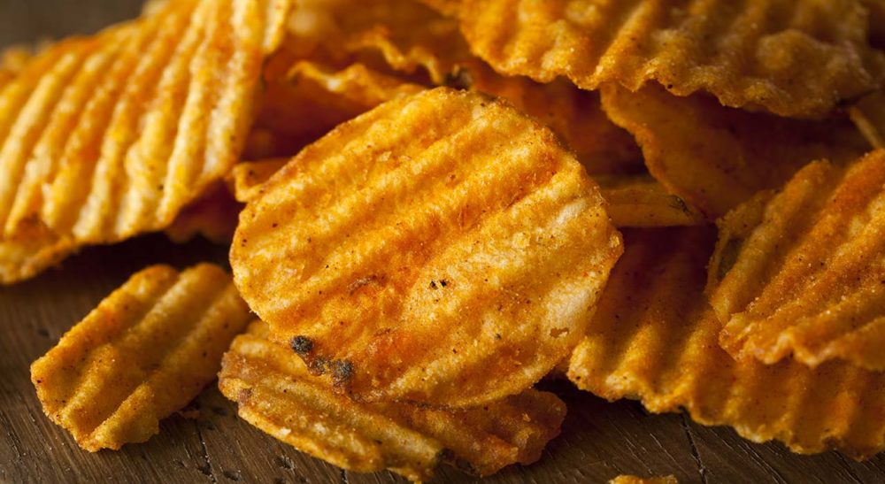 A pile of crinkle cut barbecue potato chips seasoned with DFA seasoning powder.