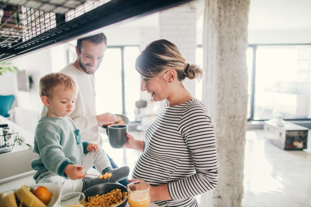 Photo of a young family preparing breakfast together in their kitchen